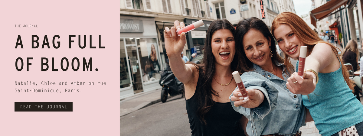 A bag full of Bloom — Natalie, Chloe and Amber on rue Saint-Dominique in Paris, each holding out a Bloom Lip Gloss. Read the photoshoot story in the Journal.